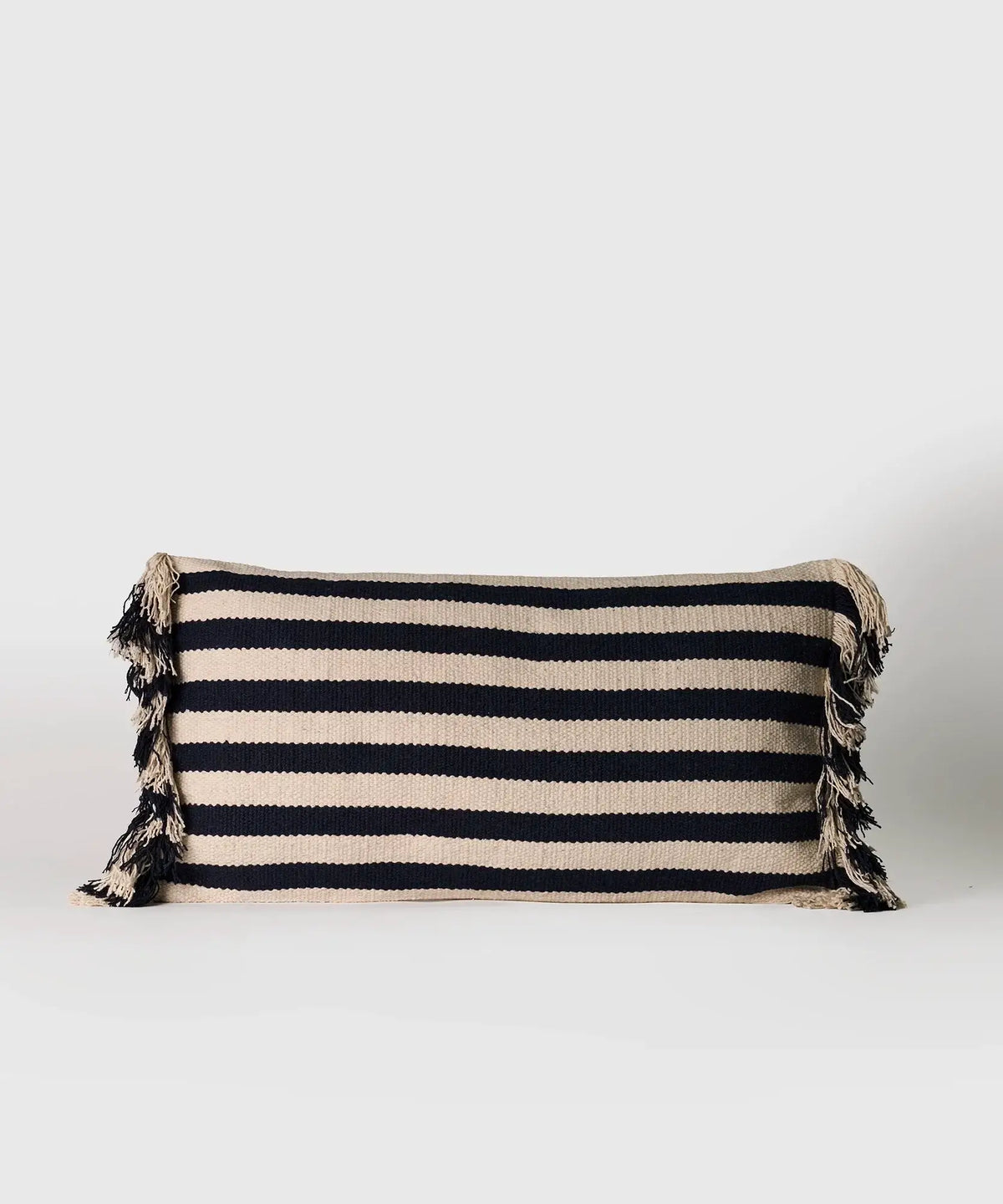 Cojín Líneas de algodón con líneas y flecos en los costados, marca Lounge, tamaño 30 x 60 cm.