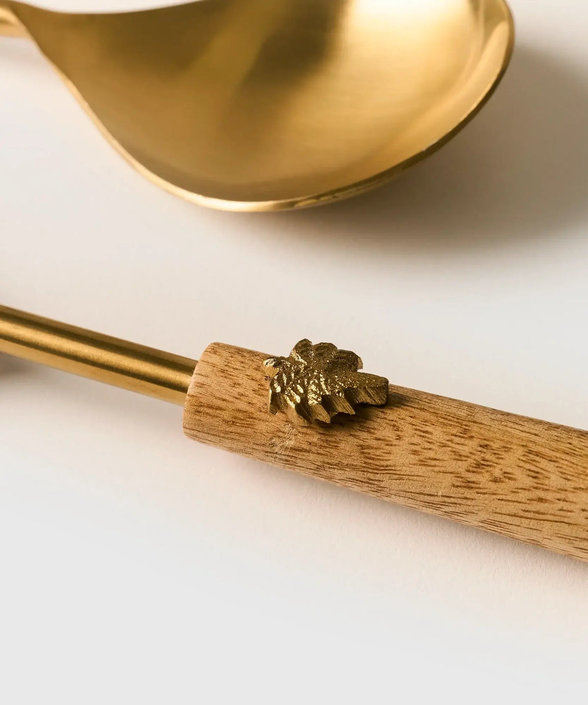 Set Cubiertos Abejas de Lounge, cuchara con detalle dorado y mango de madera.
