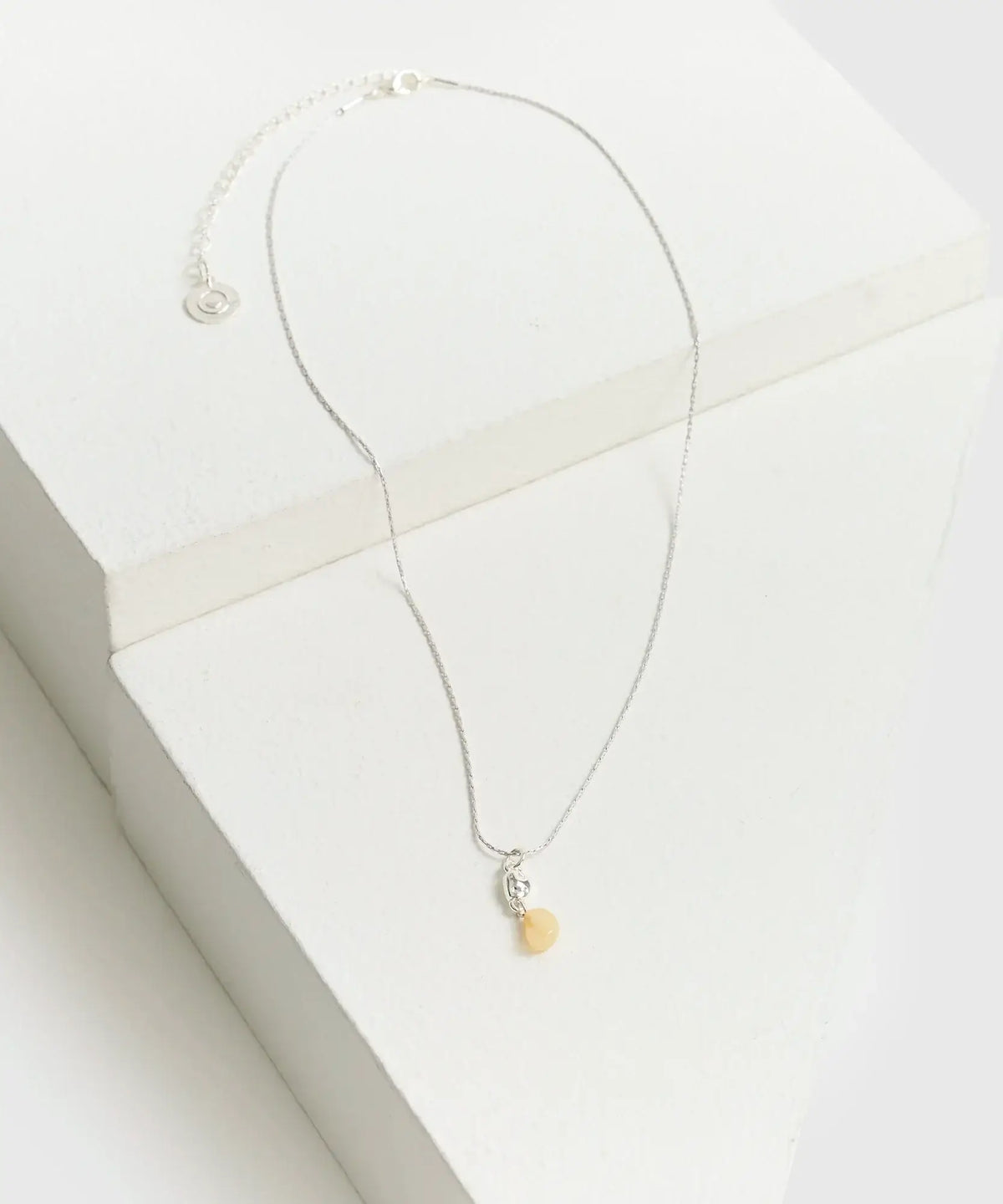 Collar Mini Piedra de Lounge con cadena delgada y mini piedra colgante sobre fondo blanco.