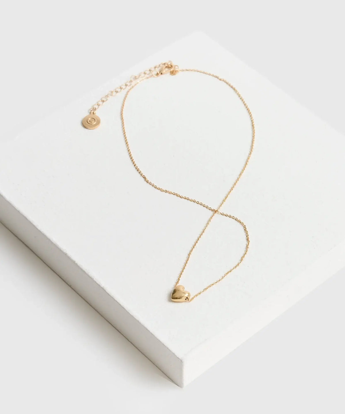 Collar Corazón de cadena delgada con charm de corazón, marca Lounge, presentado en caja blanca.
