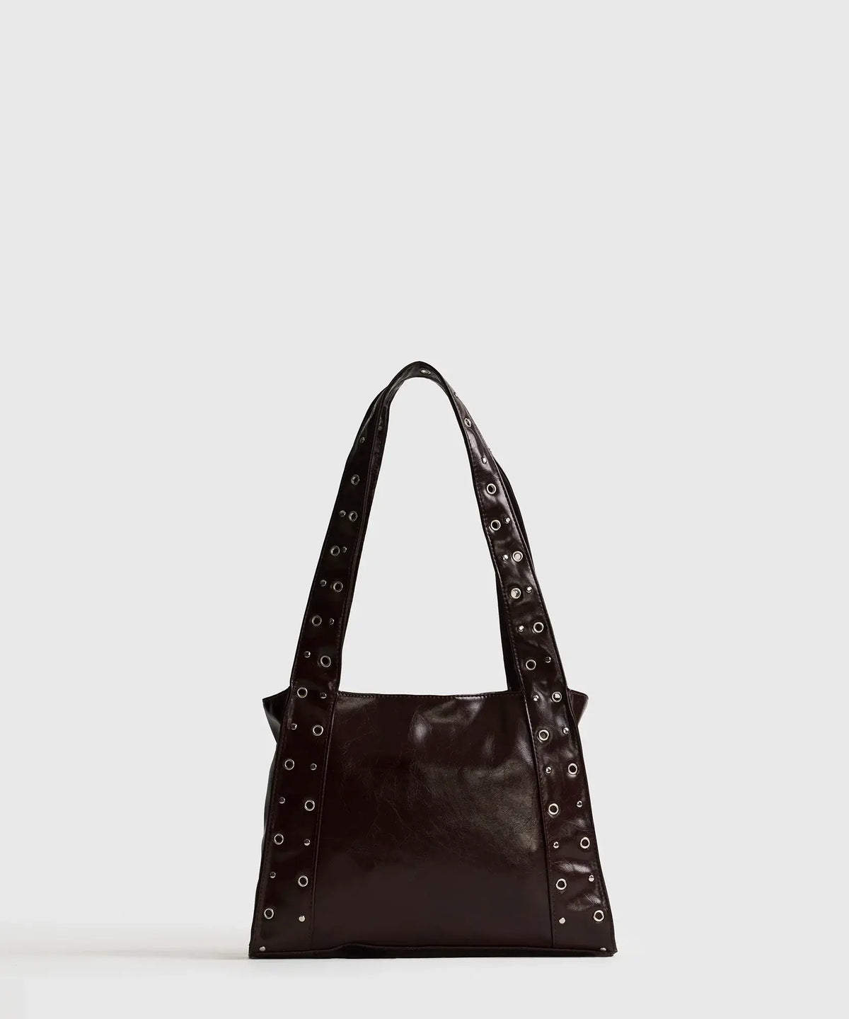Cartera De Hombro Charol Eyelets de la marca Lounge, en charol oscuro con eyelets y detalles metálicos.