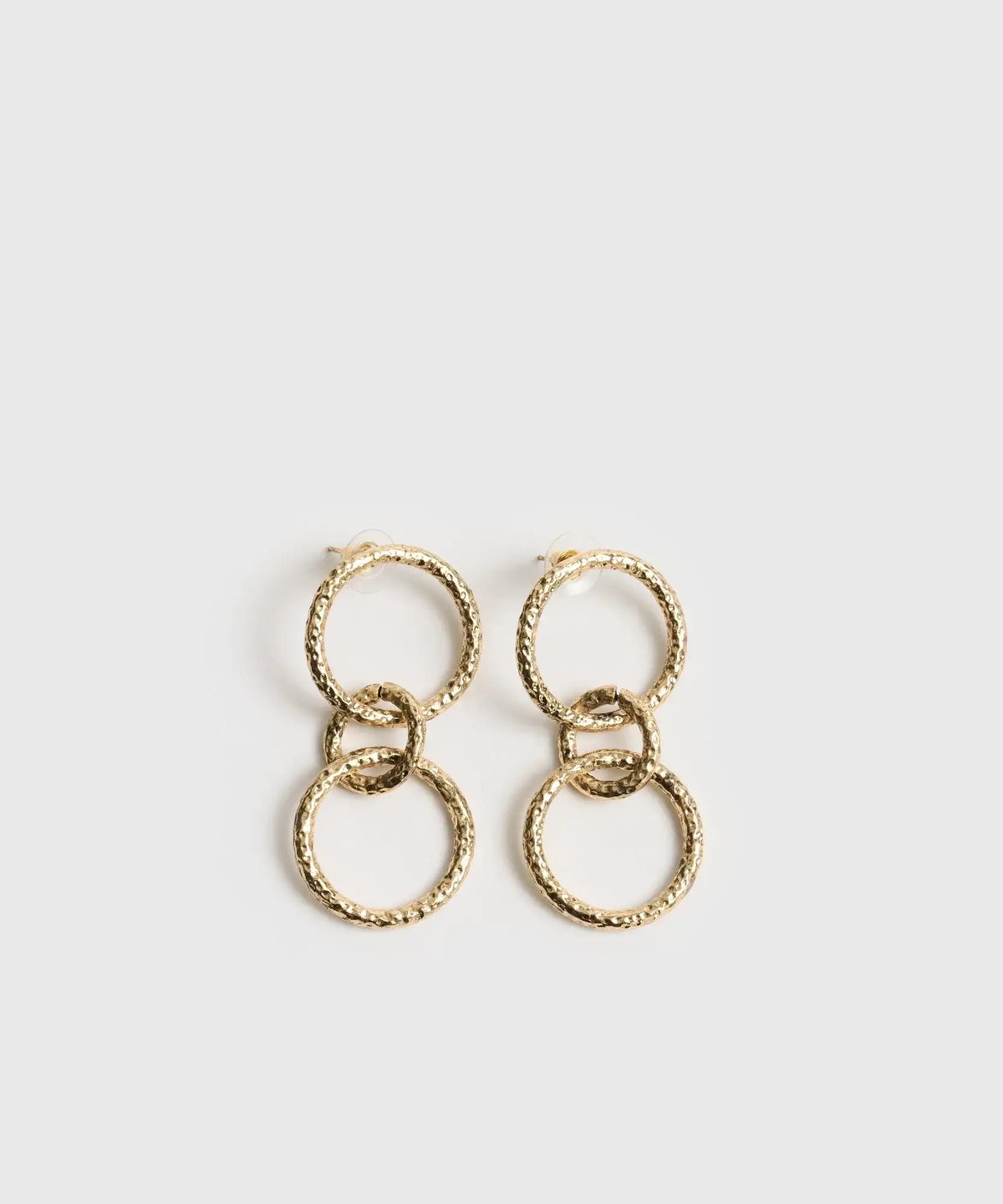 Aros Círculos Boho dorados con tres círculos colgantes y acabado texturizado de la marca Lounge.
