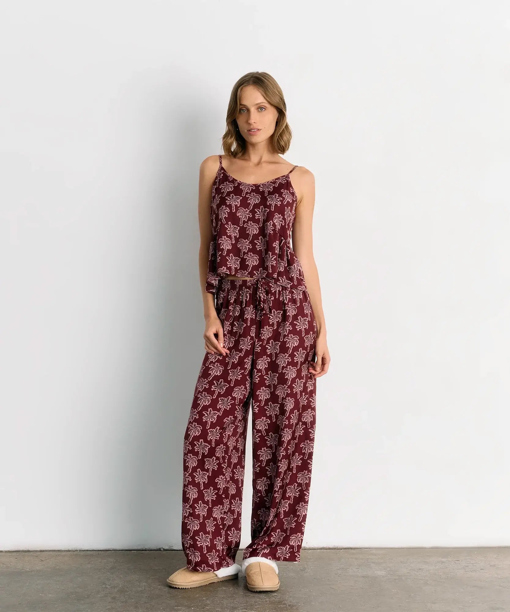 Pijama Satinado Palmeras de Lounge en color burdeos con estampado de palmeras y pantalón de pretina ajustable.
