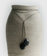 Collar Envolvente largo con mostacillas y piedras de resina, presentado sobre un soporte elegante.
