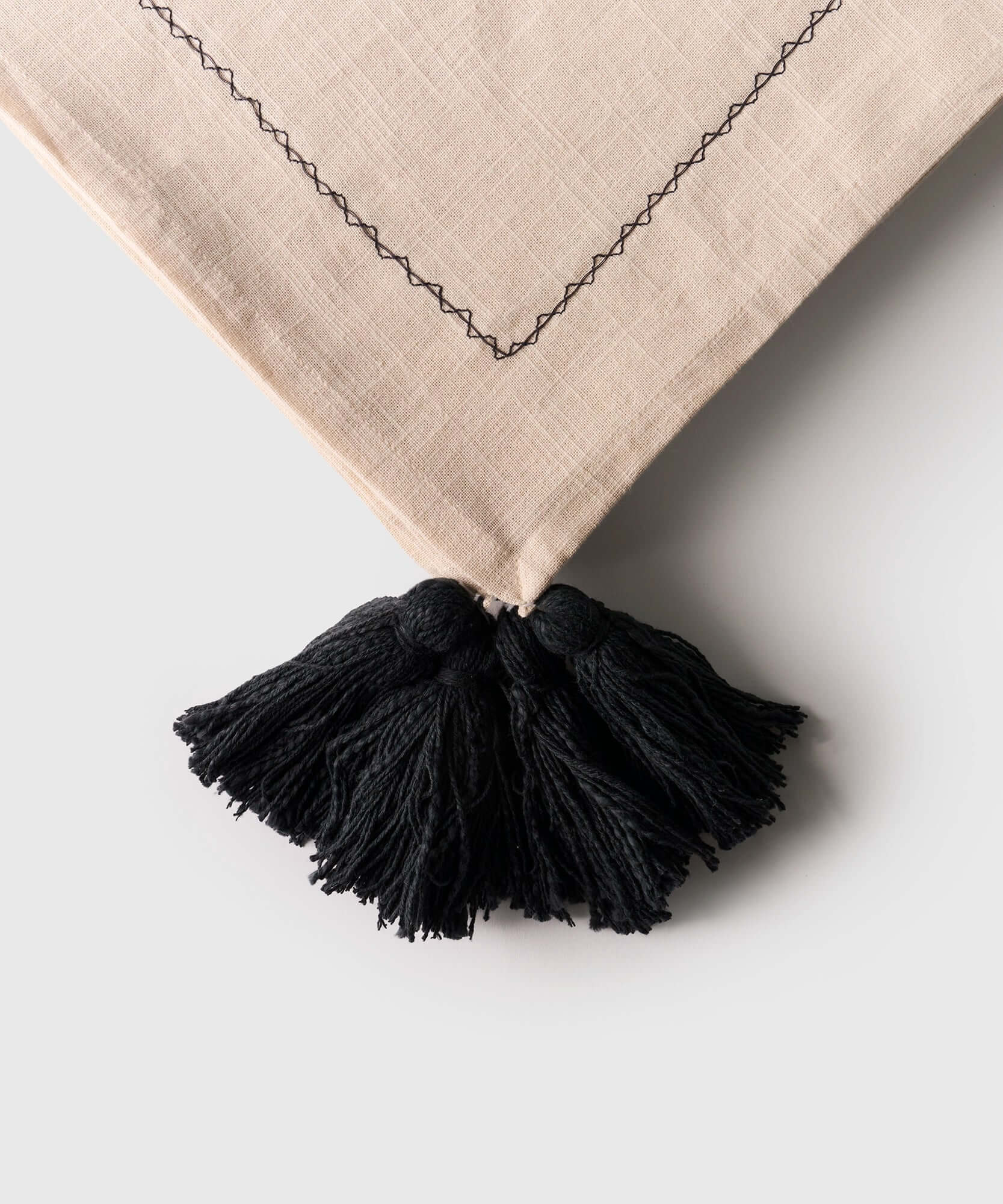 Manta Palmeras Bordadas de Lounge con bordes de tassel negro, detalle de algodón beige.
