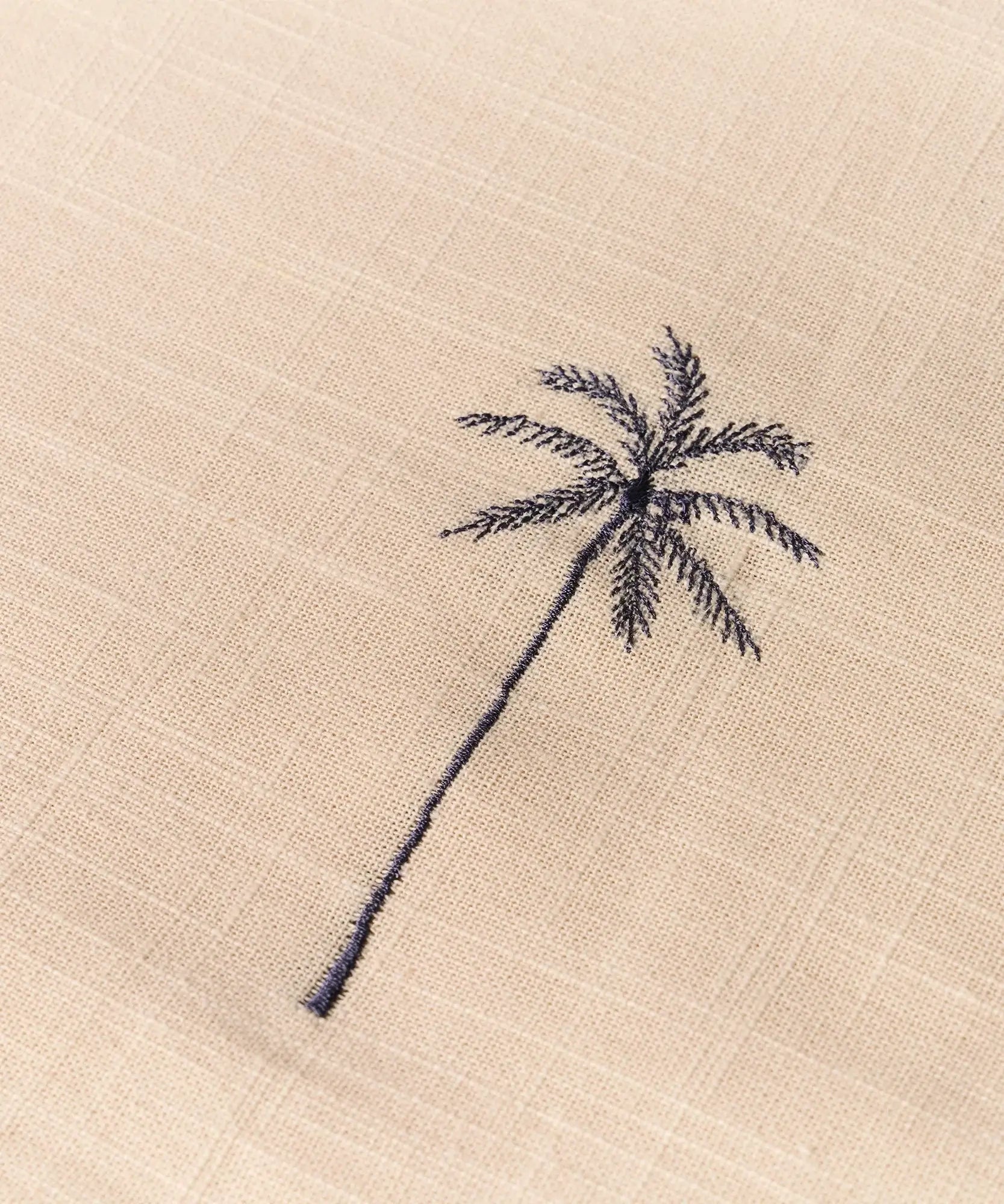 Mantel Palmeras Bordadas con diseño de palmera bordada en tela clara.