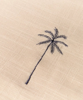 Mantel Palmeras Bordadas con diseño de palmera bordada en tela clara.