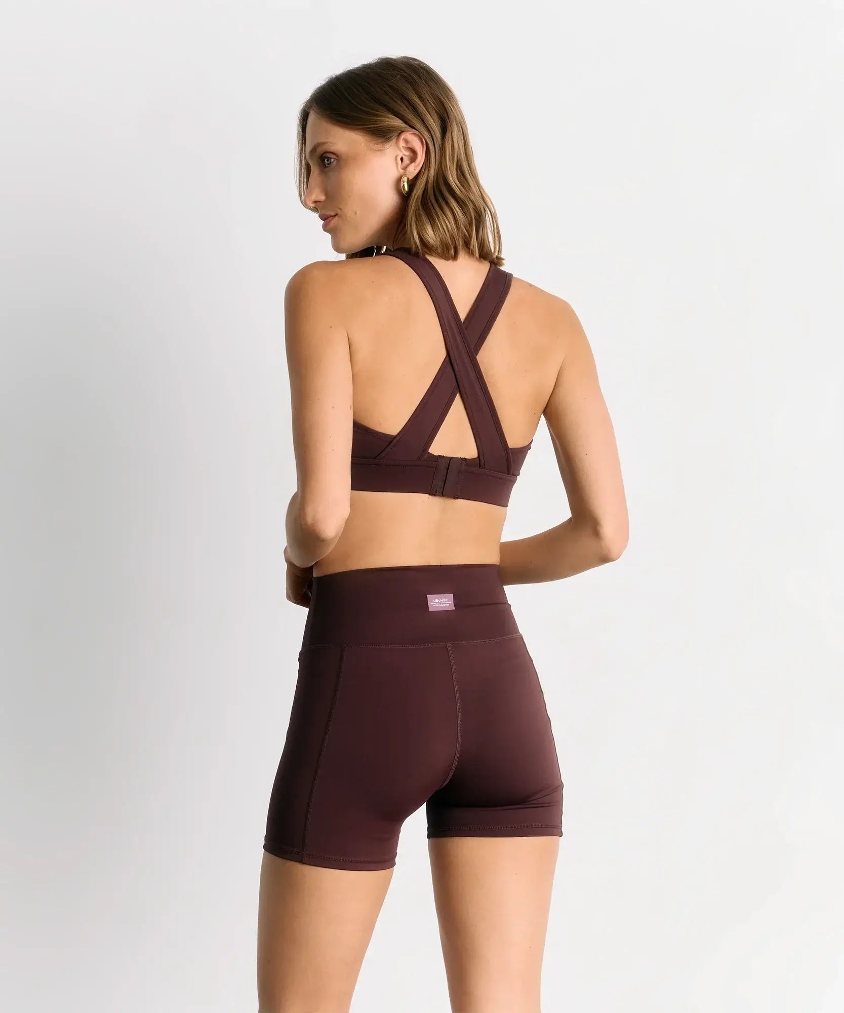Mujer usando Peto Deportivo Unicolor Active de Lounge, con diseño cruzado en la espalda y tejido elástico.