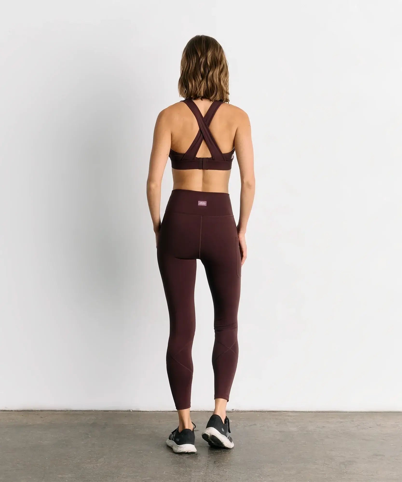 Mujer con calza deportiva unicolor Active de Lounge, vista trasera, ideal para gym y yoga.