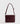 Cartera Bandolera Tachas de Lounge, color burdeos, con strap ajustable y tachas en la parte frontal.