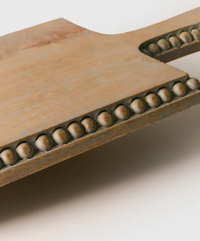 Tabla Madera Envejecida de Lounge. Detalle de bolas en los bordes de la tabla rectangular de madera gastada.