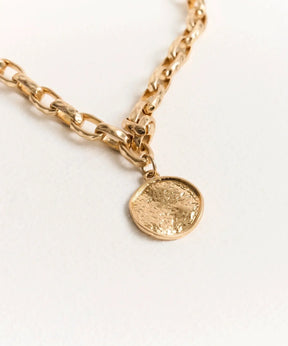 Collar Charm Machacado de Lounge con cadena gruesa y charm redondo machacado en dorado.