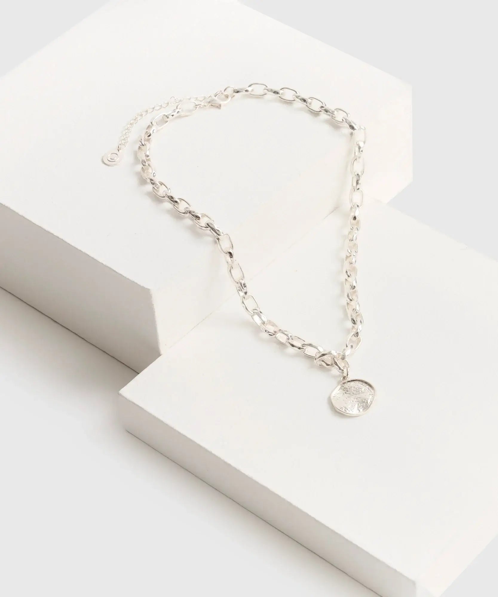 Collar Charm Machacado de marca Lounge, con cadena gruesa y charm redondo machacado sobre fondo blanco.