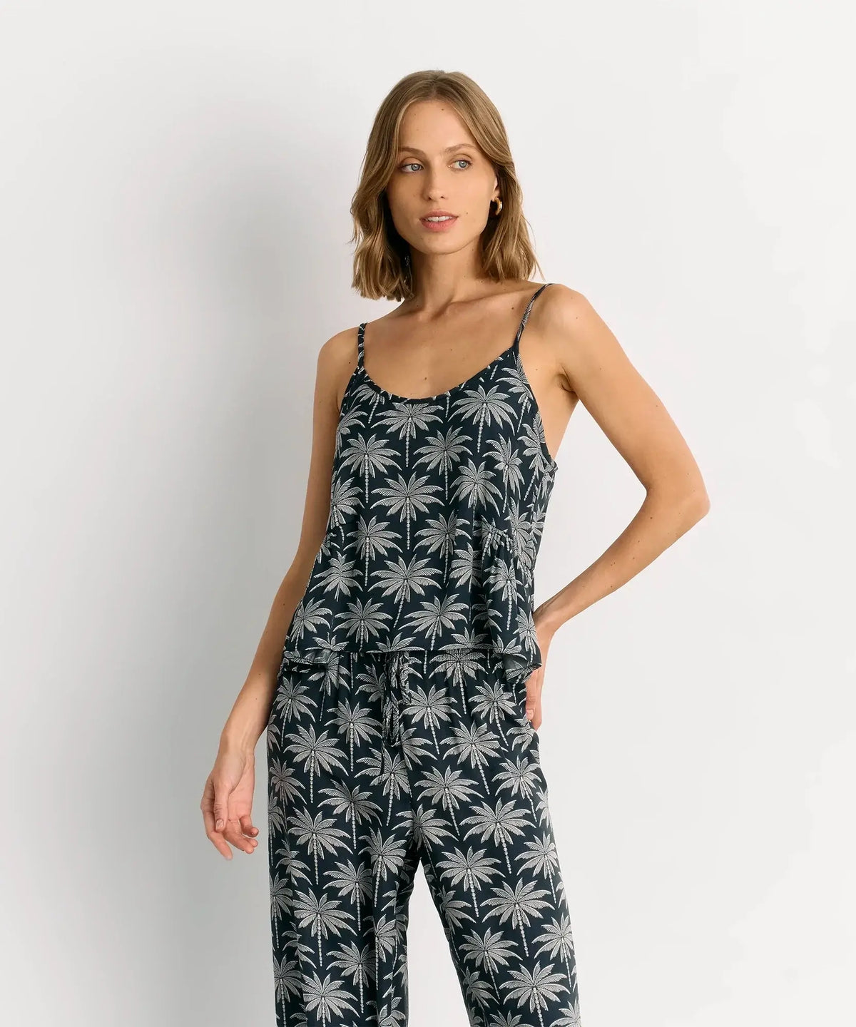 Mujer usando el Pijama Satinado Palmeras de Lounge, con diseño de palmeras y vuelo delicado.