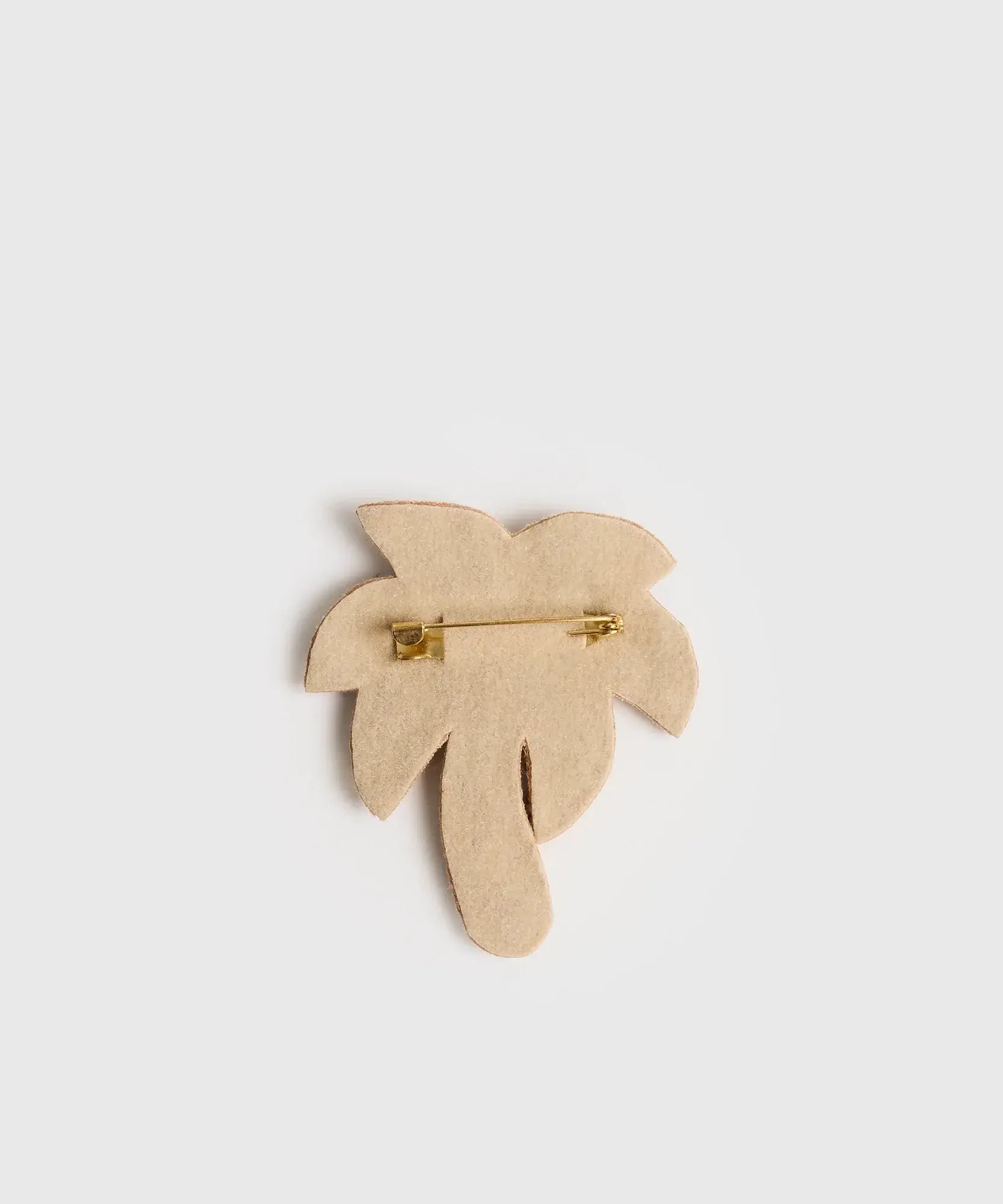 Prendedor Palmera de Lounge con diseño de palmera en color beige. Accesorio moderno para complementar tu outfit.