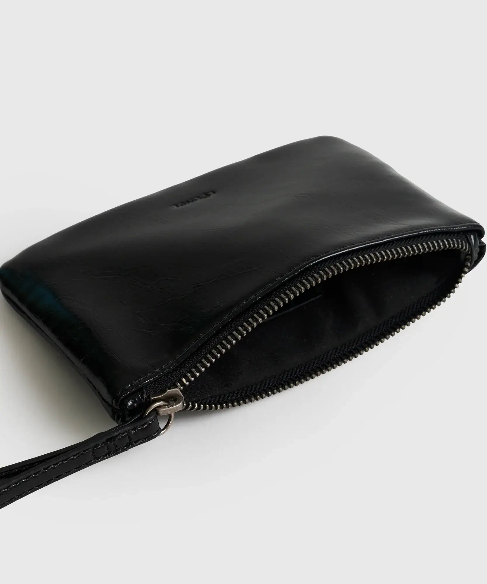 Billetera Tipo Estuche Lounge de color negro con cierre metálico y strap corto para mayor comodidad.