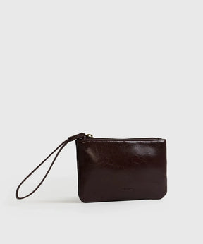 Billetera Tipo Estuche Lounge de cuero marrón, con cierre metálico y strap corto para mayor comodidad y seguridad.
