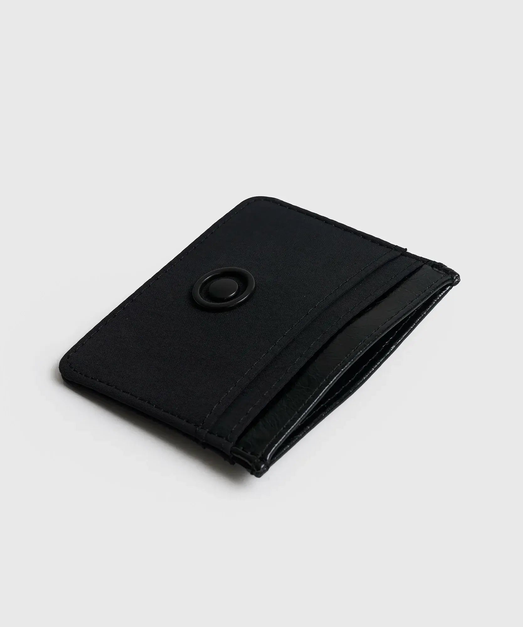 Tarjetero Básico Lounge de nylon negro con borde superior efecto cuero y compartimientos.
