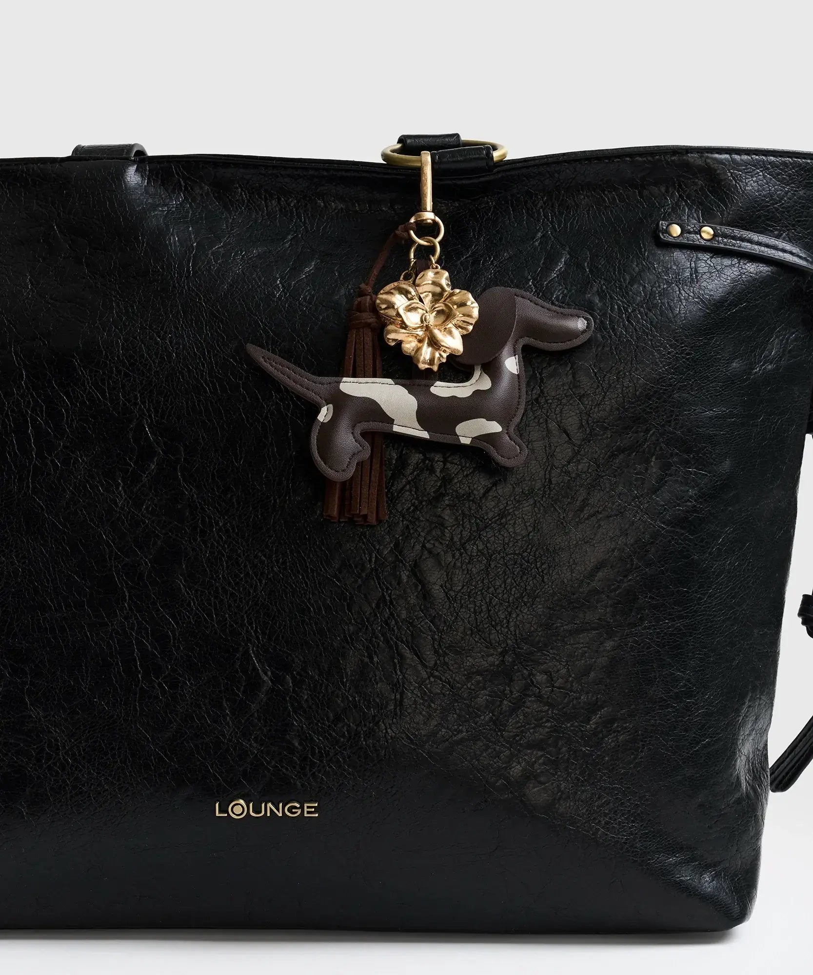 Llavero Perro Salchicha con charm y tassel de la marca Lounge en bolso negro.