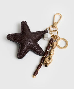 Llavero Estrella de Lounge con charm de estrella y mostacillas en tonos marrón y dorado.