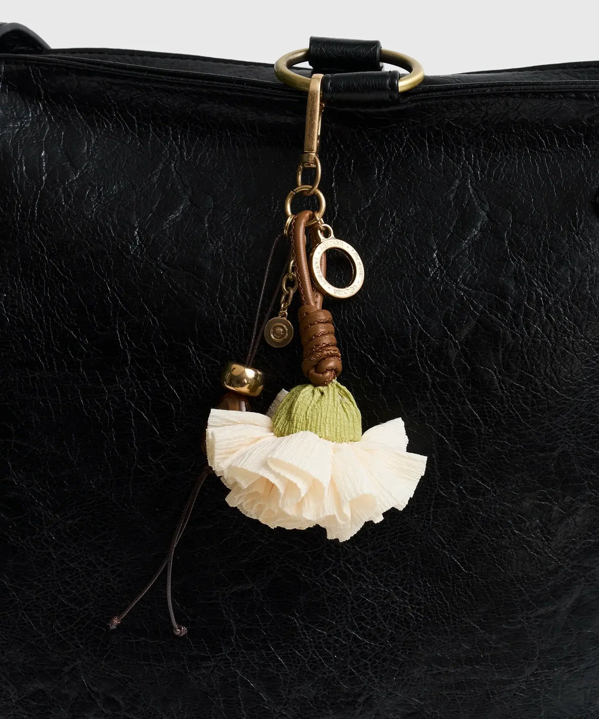 Llavero Flor de Lounge con flor blanca, detalles en piedras, y diseño elegante para tu bolso.