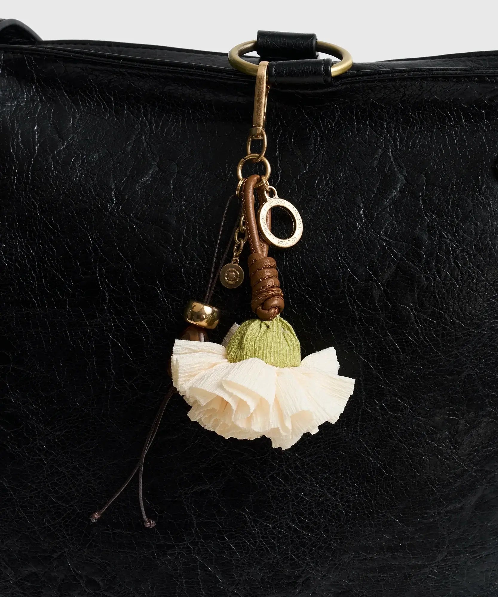 Llavero Flor de Lounge con flor blanca, detalles en piedras, y diseño elegante para tu bolso.