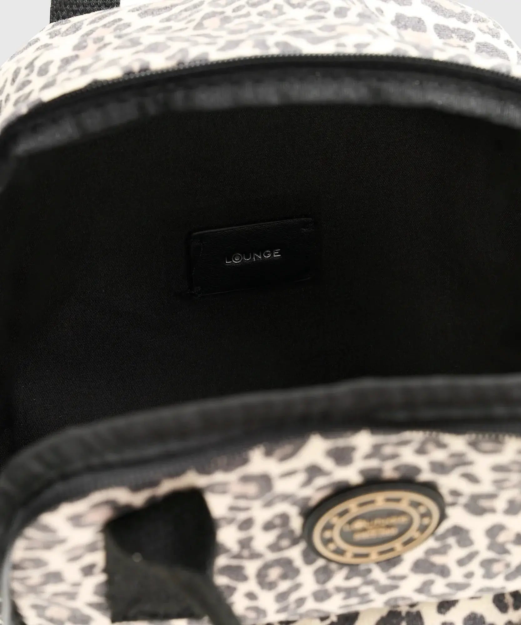 Interior de mochila Canvas de la marca Lounge, muestra el bolsillo principal con etiqueta Lounge.