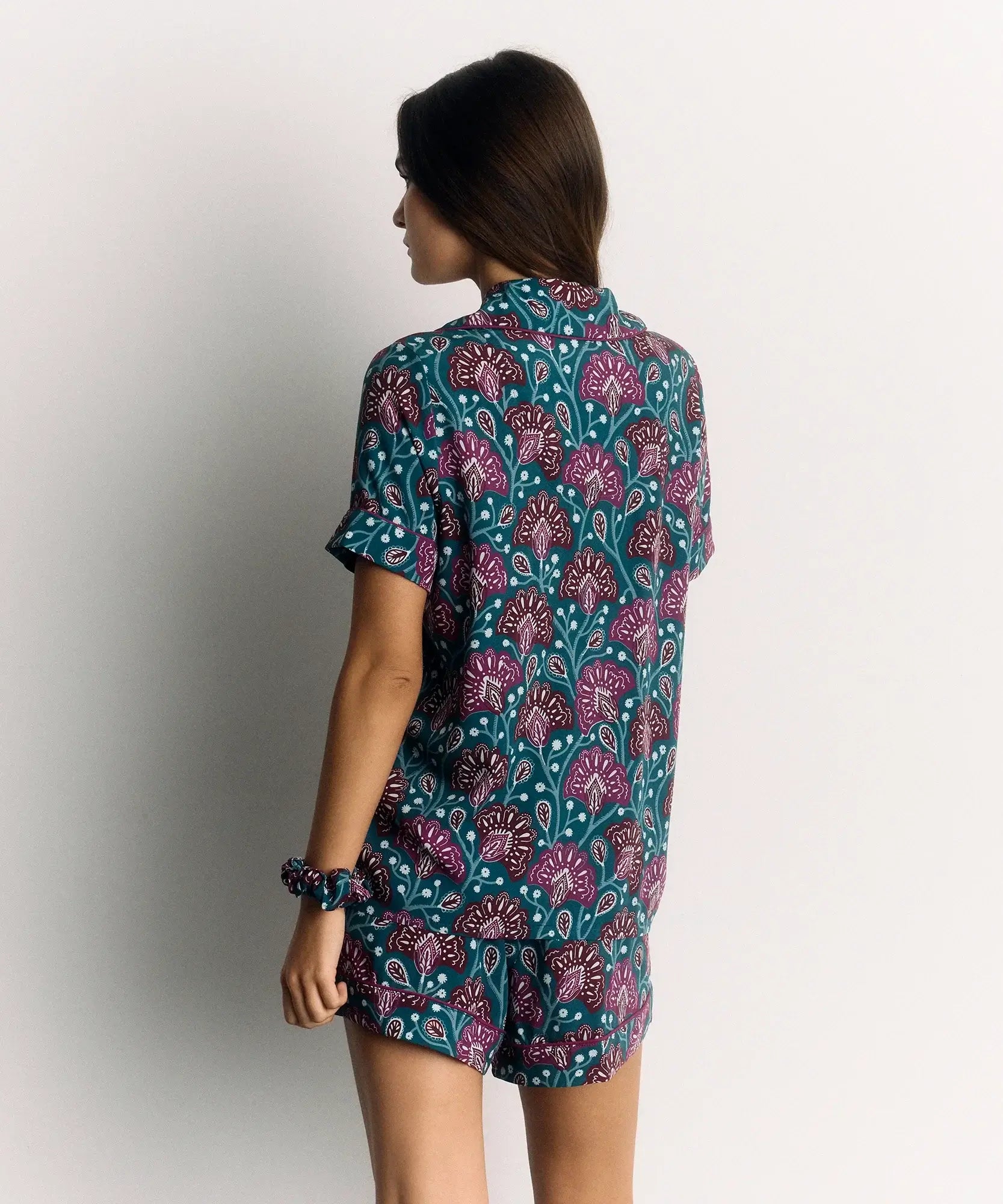 Mujer usando un Set Pijama Flores de Lounge, con diseño de flores en colores vibrantes, vista trasera.