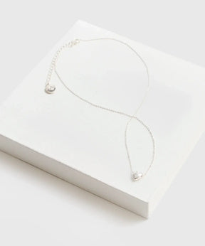 Collar Corazón de cadena delgada con charm de corazón de la marca Lounge sobre una caja blanca.