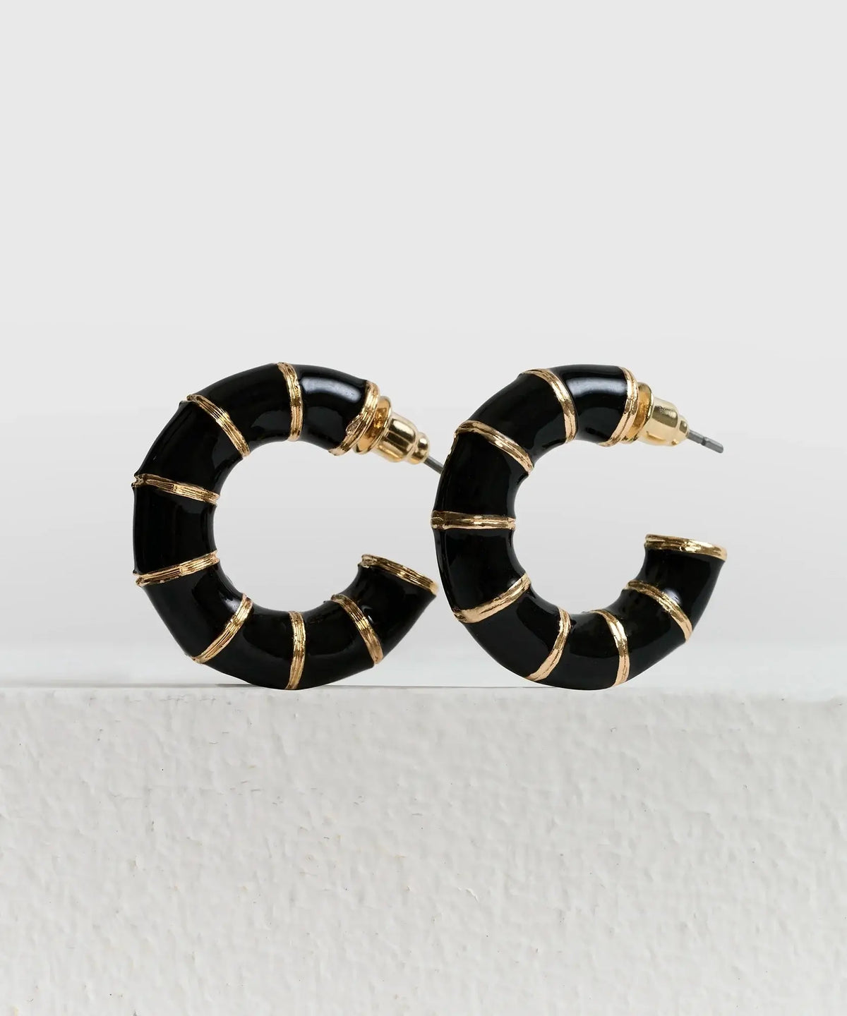 Aros Argollas Resina de Lounge, gruesas de resina negras con detalles metálicos dorados.