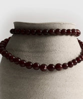 Collar Extra Largo de Lounge con piedras de diferentes tamaños sobre una maceta de cerámica.