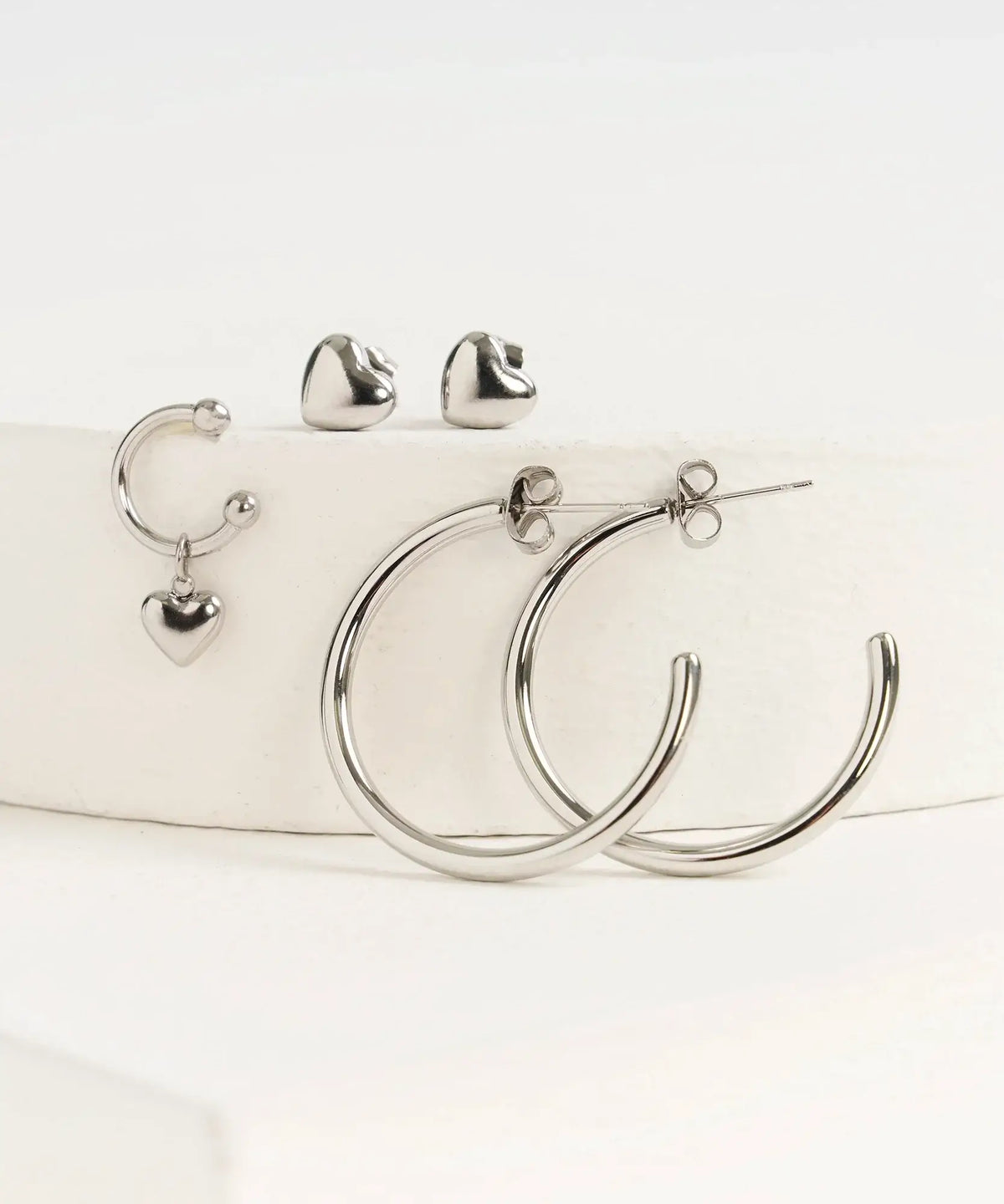 Set Aros Street de Lounge: set de tres aros con diseño de corazones y argollas semi abiertas.
