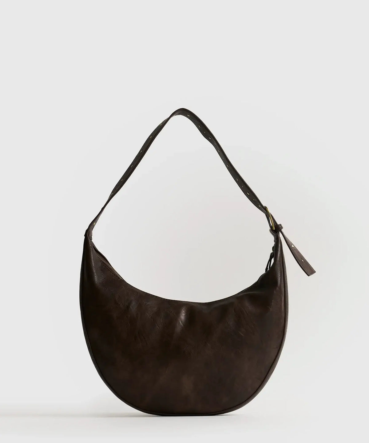 Cartera De Hombro Boheme de Lounge, tipo banano con strap ajustable y detalles bohemios en color marrón.