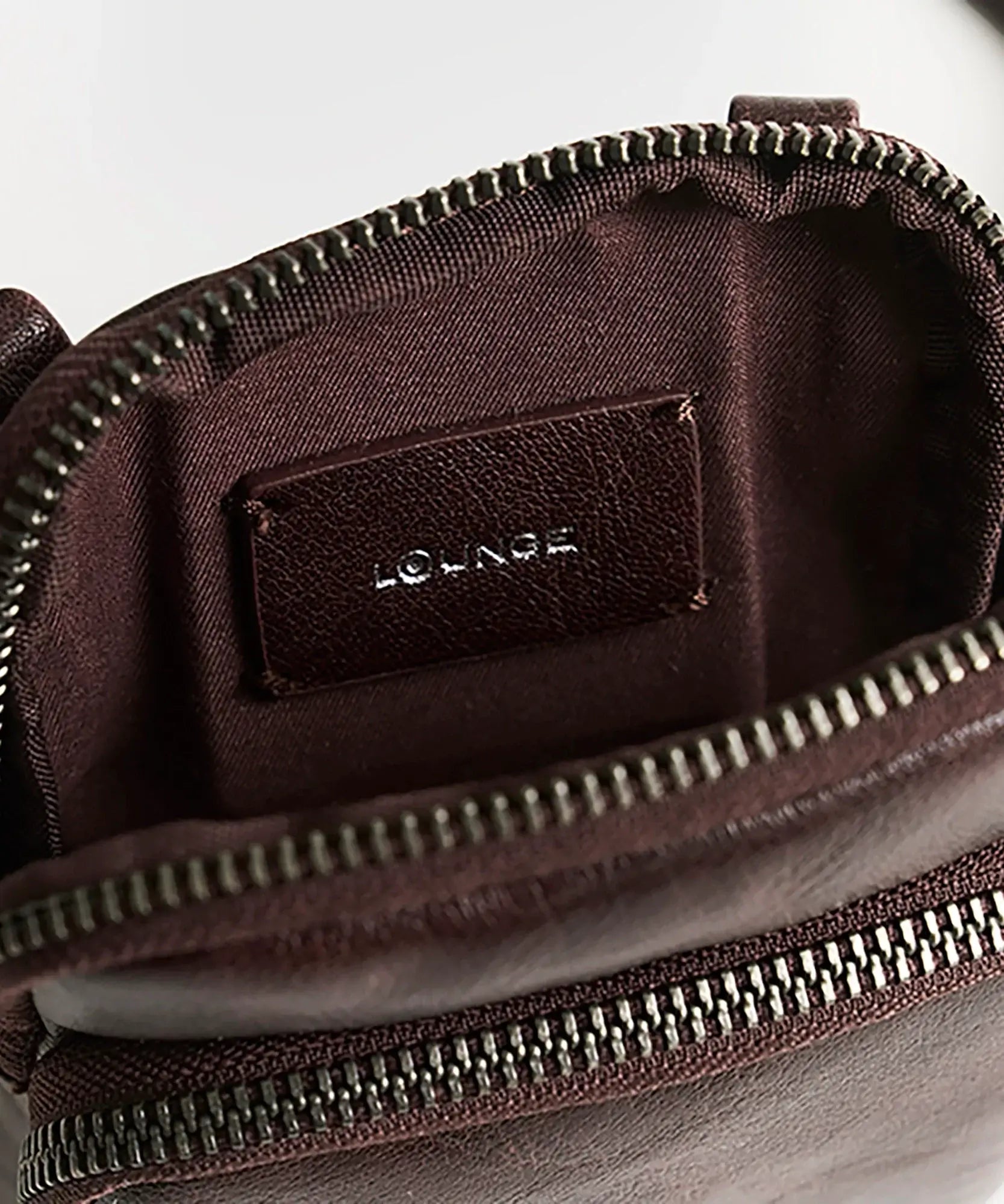 Interior view of Mini Cartera Icons Woman by Lounge showing zipper and logo tag.