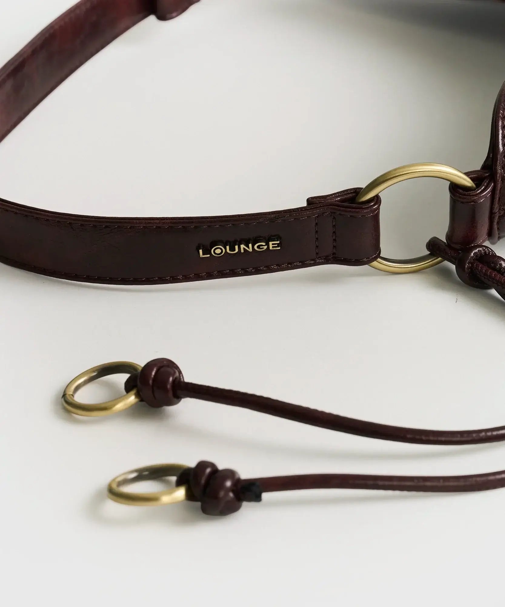 Cartera De Hombro Asimétrica asa ajustable de Lounge con diseño de argollas y detalles en dorado.