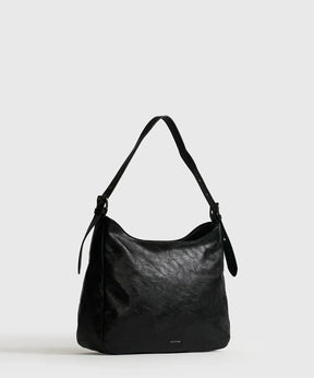 Cartera De Hombro Eclat en color negro de Lounge, con strap ajustable y amplio compartimento principal.