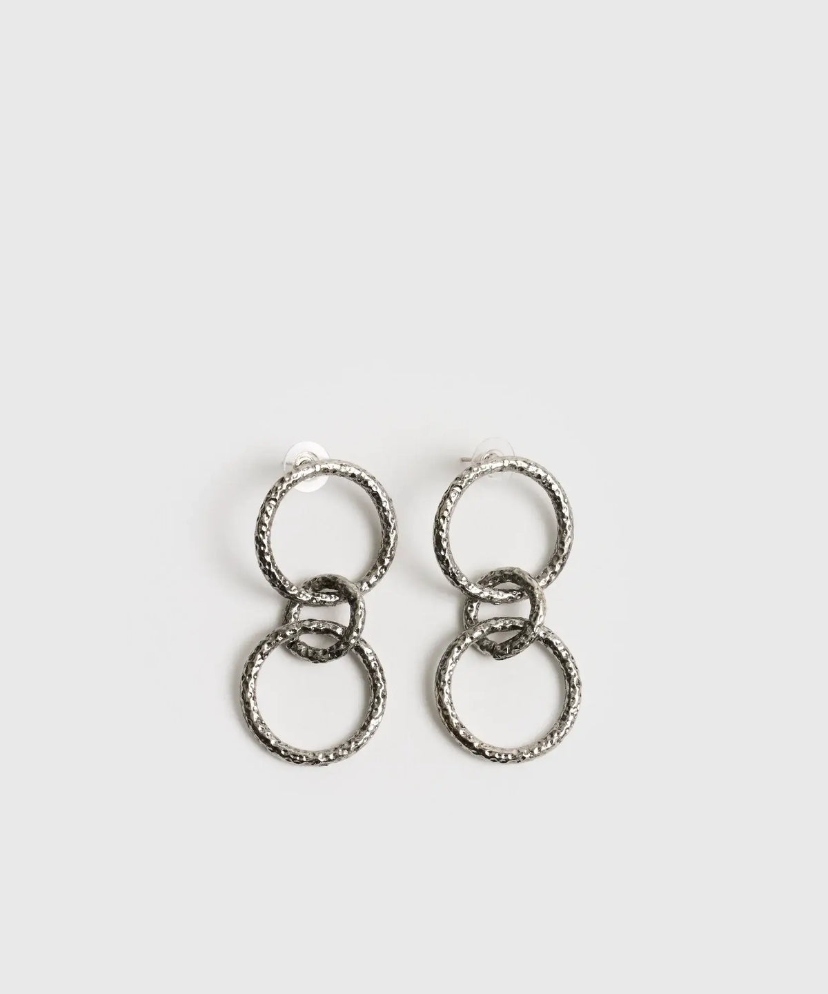 Aros Círculos Boho de Lounge, largos con tres círculos colgantes en acabado plateado y texturizado.