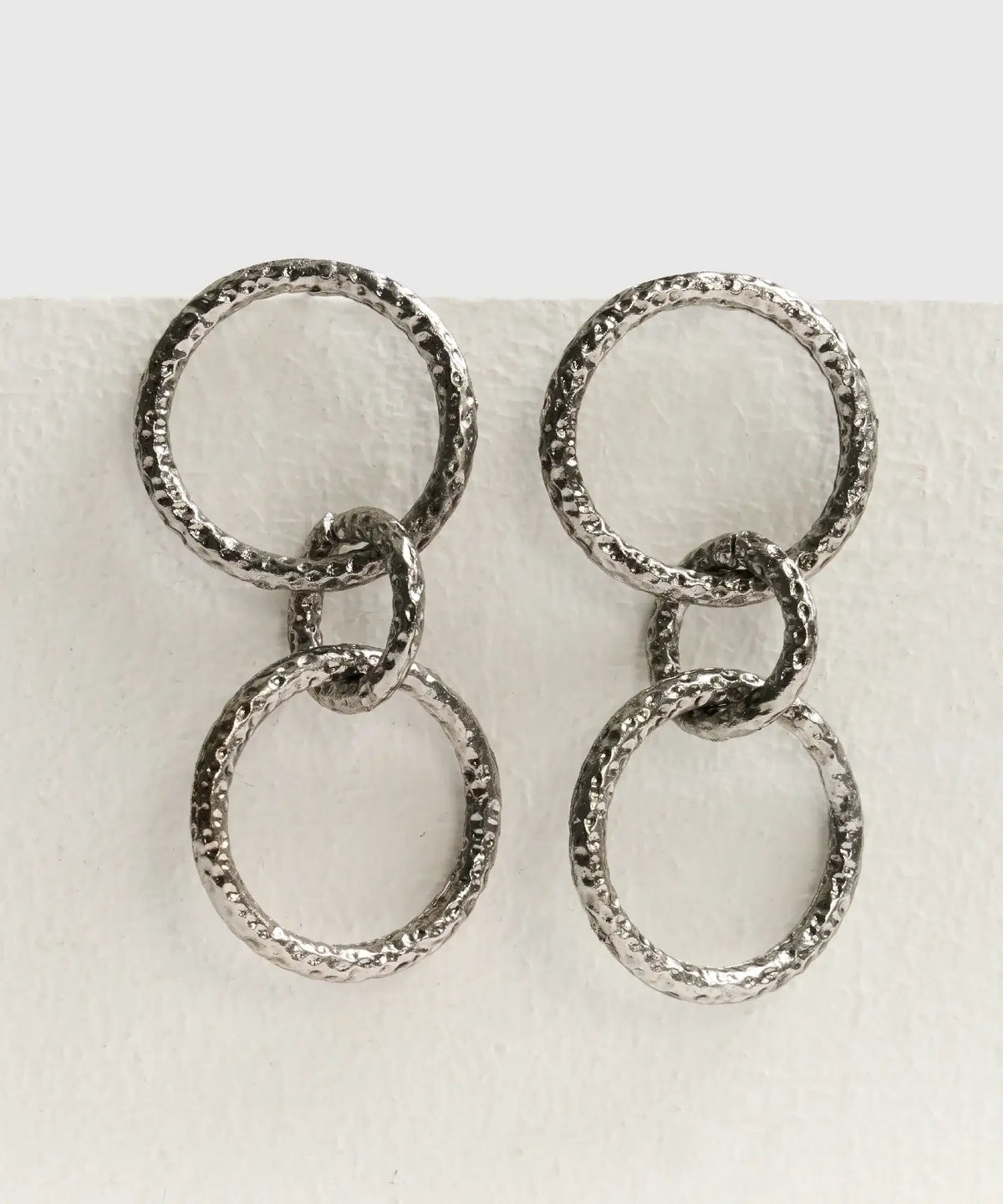 Aros Círculos Boho de Lounge, aros largos con tres círculos colgantes y acabado texturizado.