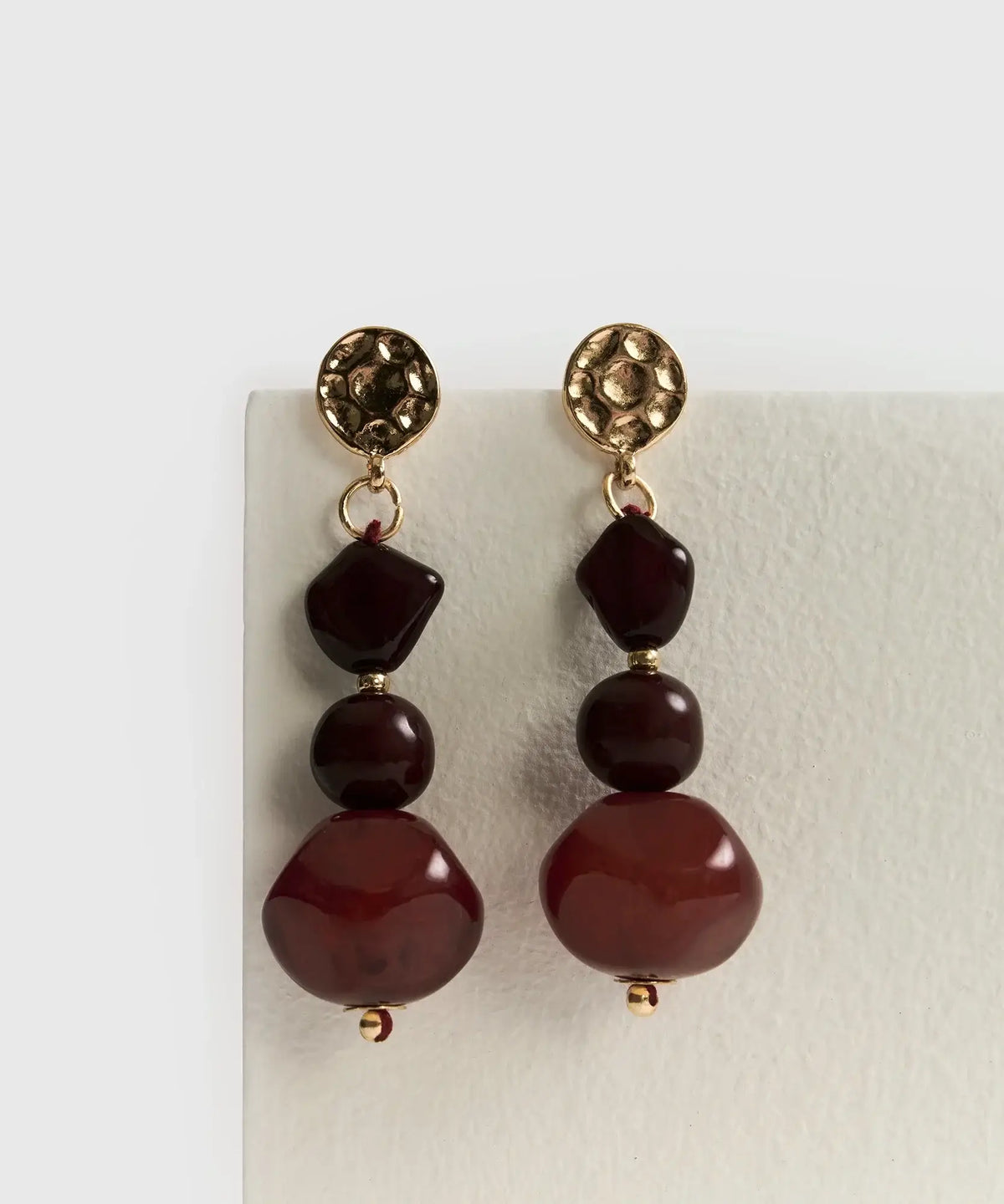 Aros Colgantes Piedra Resina de Lounge con piedras rojas en diseño largo y elegante.