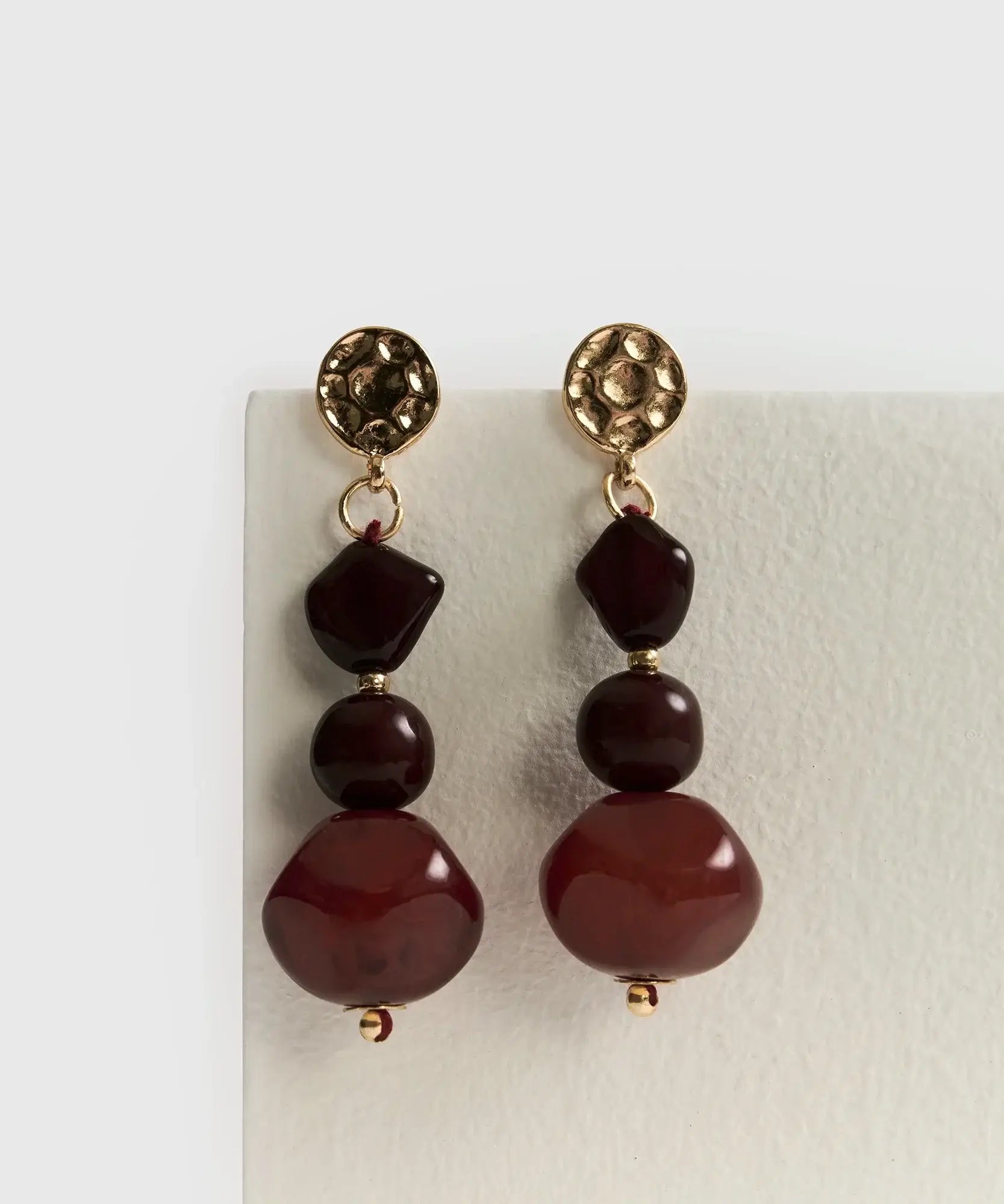 Aros Colgantes Piedra Resina de Lounge con piedras rojas en diseño largo y elegante.