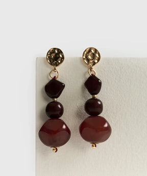 Aros Colgantes Piedra Resina de Lounge con piedras rojas en diseño largo y elegante.