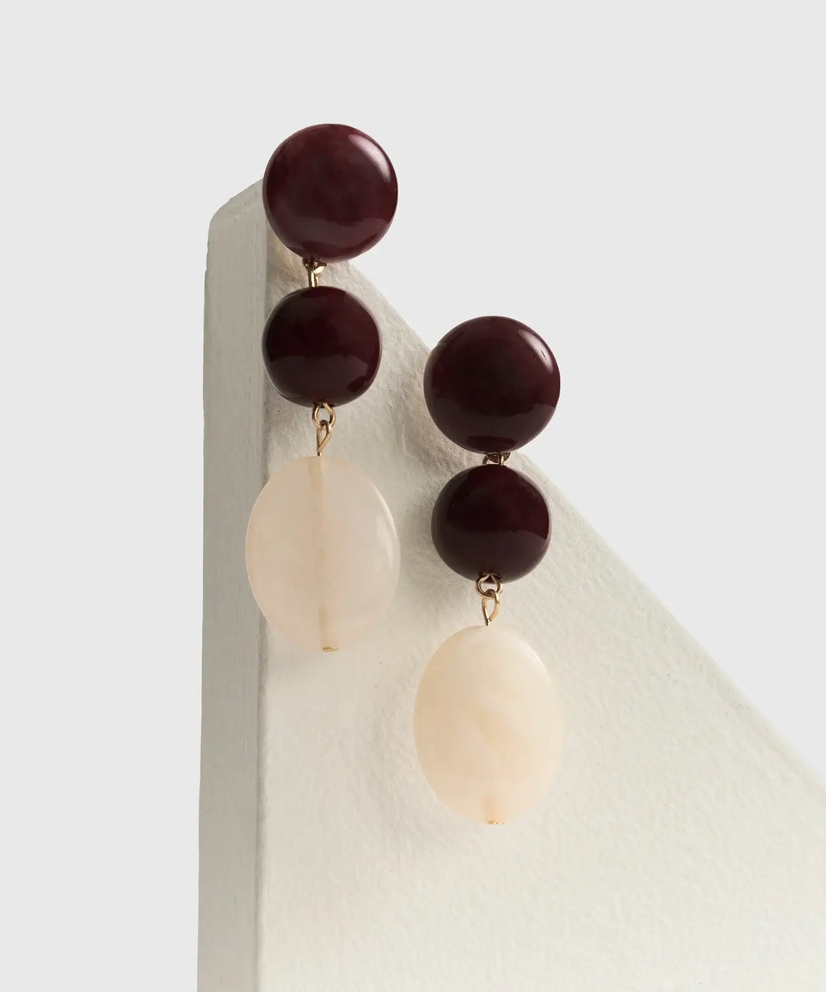 Aros Piedras Colgantes de Lounge, largos con círculos y piedras de resina en tonos rojo y blanco.