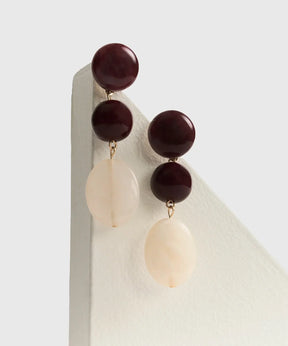 Aros Piedras Colgantes de Lounge, largos con círculos y piedras de resina en tonos rojo y blanco.