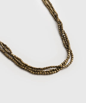 Collar Mostacillas Triple Boho de Lounge, collar de tres capas con mostacillas pequeñas en tonos dorados.